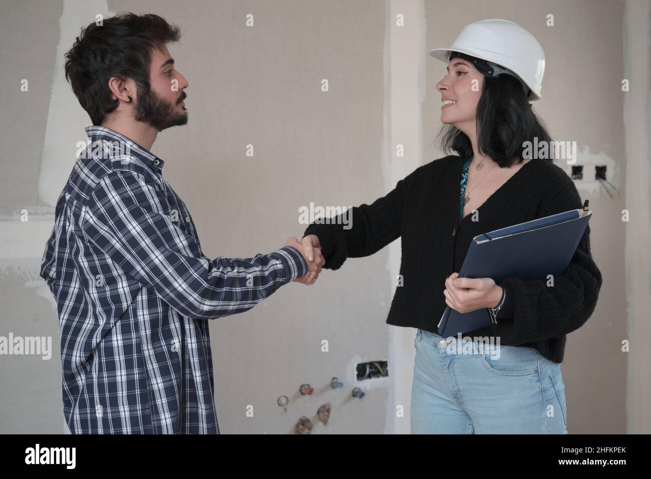 Homme et femme architecte qui se secouent la main après la signature du contrat de la maison d'achat. Banque D'Images
