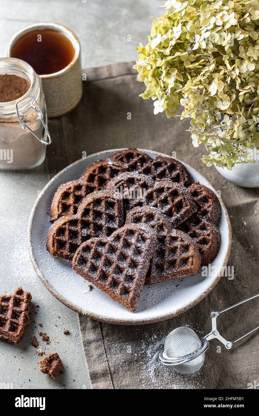 Gaufres au chocolat en forme de coeur dans plaque en céramique sur fond texturé, encore la vie pour la Saint-Valentin Banque D'Images