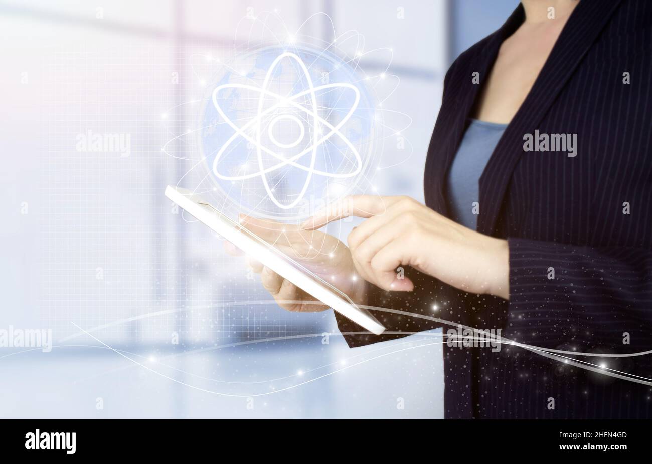 Molécule d'atome comme concept pour la science.Tablette blanche à toucher manuel avec signe d'atome de molécule d'hologramme numérique sur fond clair et flou Banque D'Images