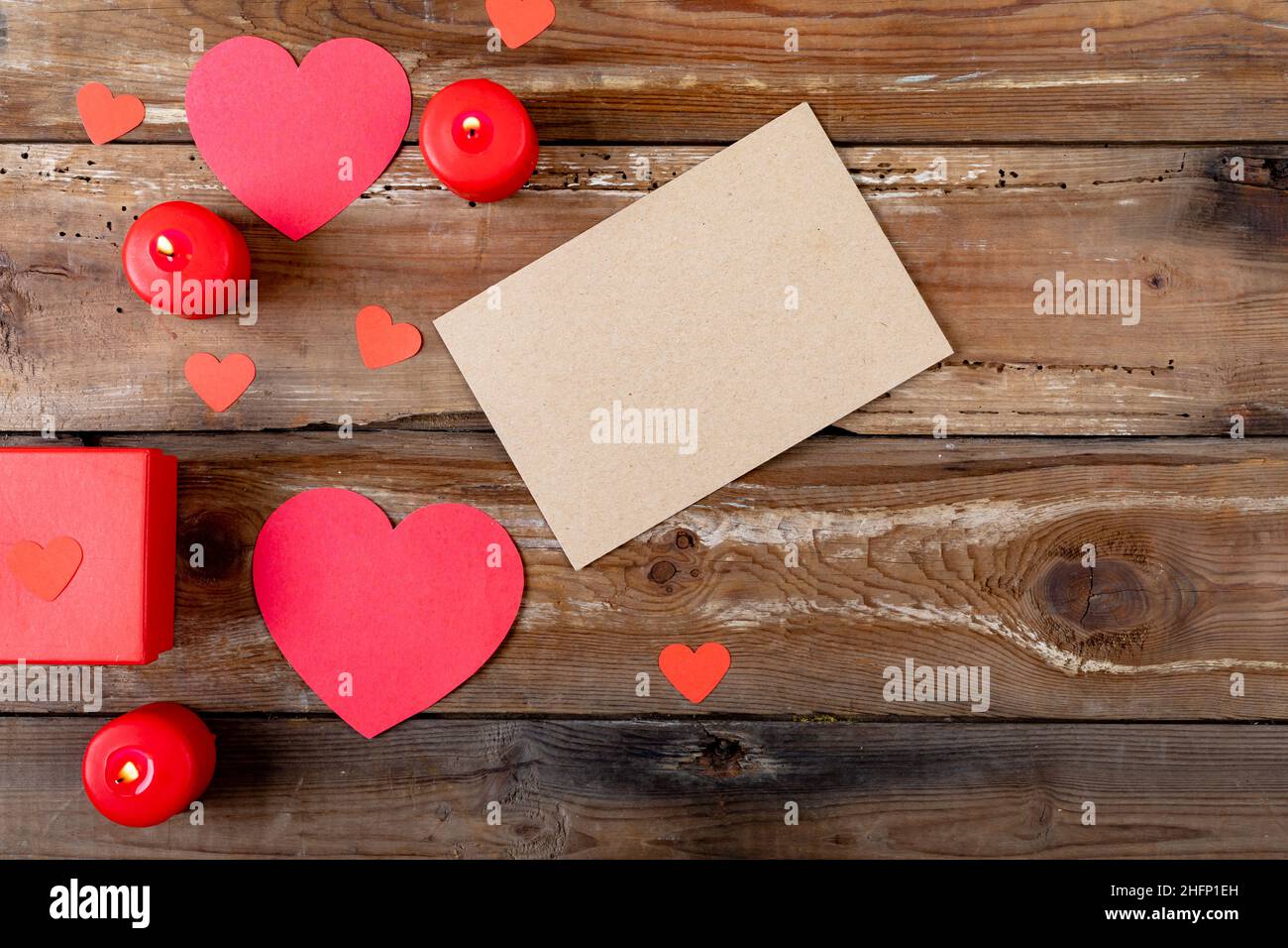Copiez l'espace sur du papier vierge en forme de coeur et en brûlant des bougies sur une table en bois Banque D'Images
