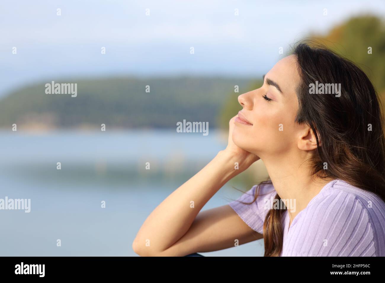 Profil d'une femme heureuse se relaxant dans un lac Banque D'Images