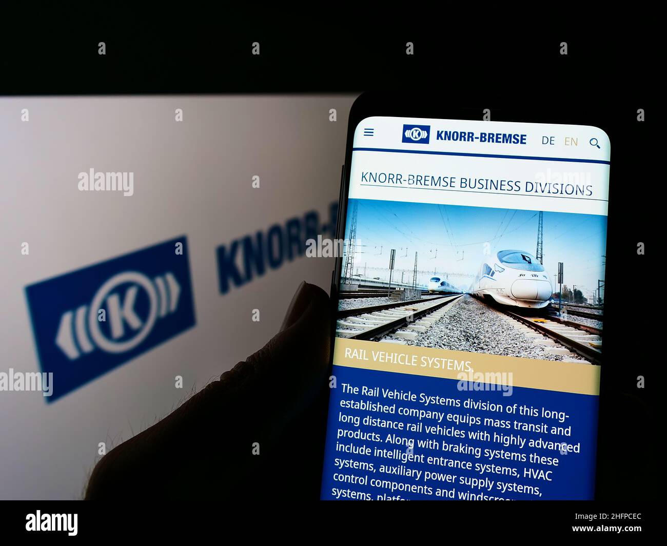 Personne tenant un téléphone portable avec le site de la société allemande de fabrication Knorr-Bremse AG sur écran devant le logo.Concentrez-vous sur le centre de l'écran du téléphone. Banque D'Images
