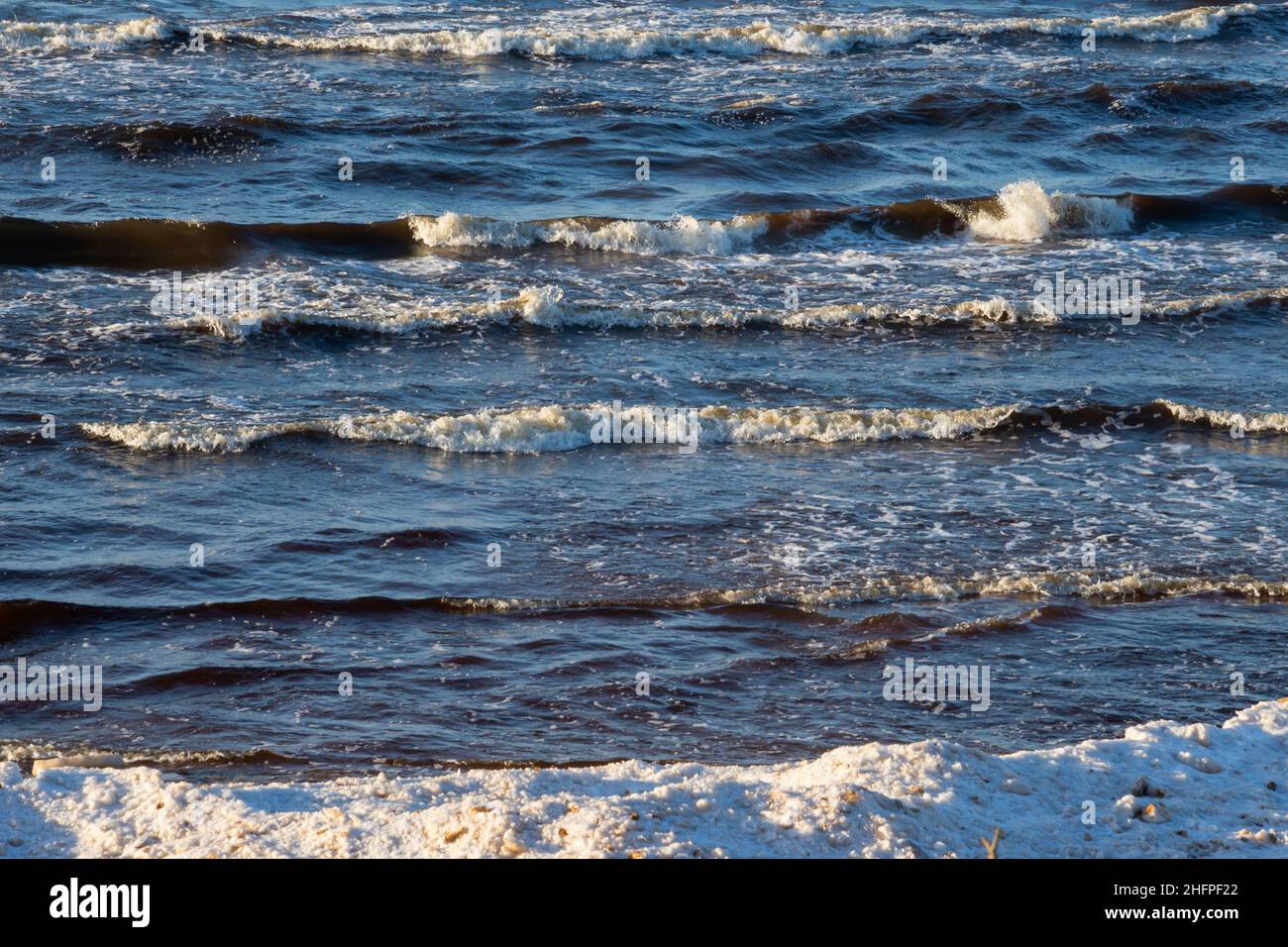 mer avec sable blanc et eau bleue avant la tempête. vagues avec des têtes blanches Banque D'Images