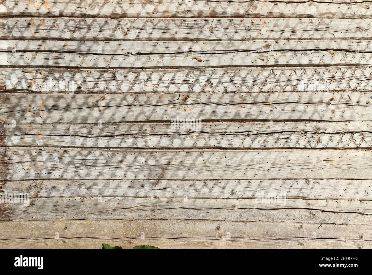 Texture du mur d'une ancienne maison de village en bois de bois avec roue et râteaux en bois vintage.Bélie Luga.Tevinichi.Bélarus. Banque D'Images