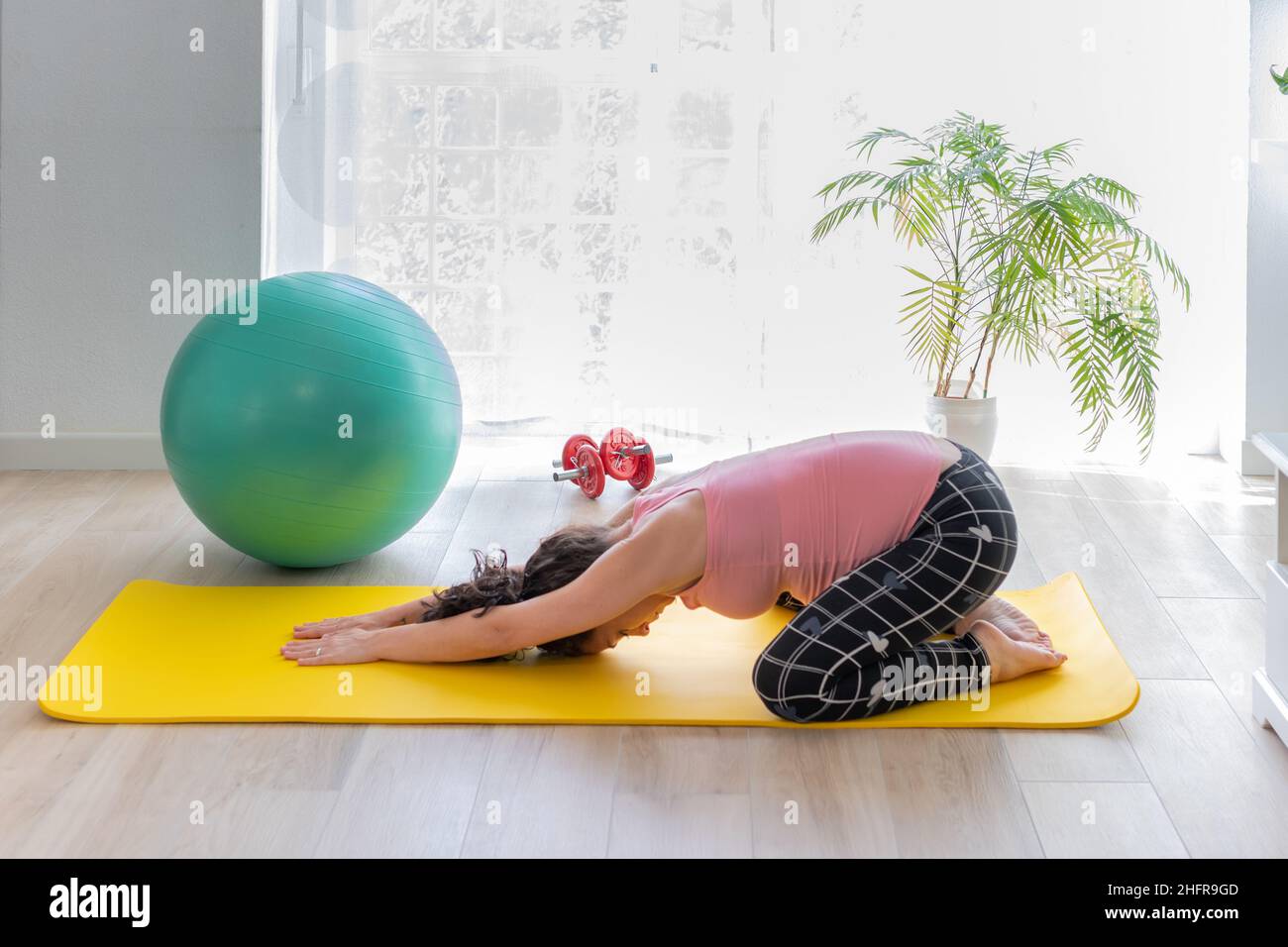 jeune femme enceinte allongé sur un tapis d'exercice faisant dos étirant à la maison.concept de soins de santé et de sport pendant la grossesse et la gestation Banque D'Images