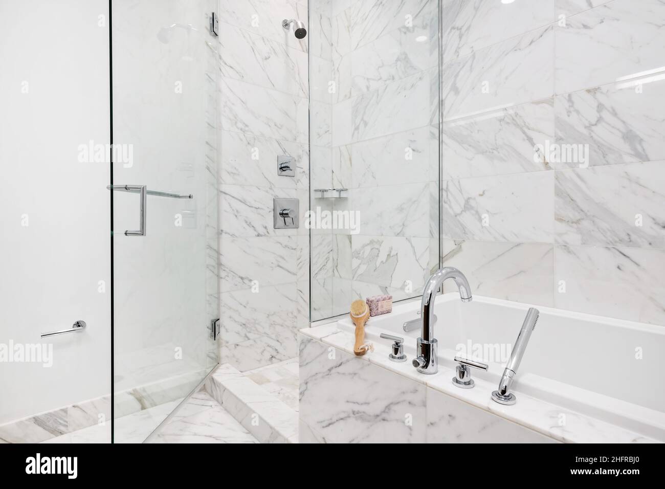 Salle de bains de luxe avec baignoire, carrelage en marbre blanc et douche à porte vitrée.Suite élégante.Design moderne et contemporain. Banque D'Images