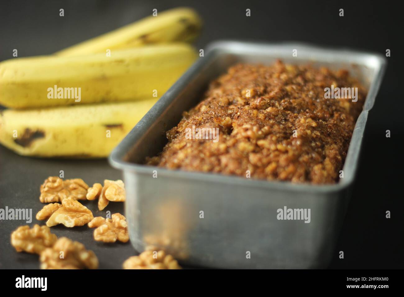 Pain à la banane fait avec de la farine de blé entier et de l'huile de coco.Cuit avec de la cannelle, du sucre et des noix pour un dessus croquant.Frais du four servi dans un rectangu Banque D'Images