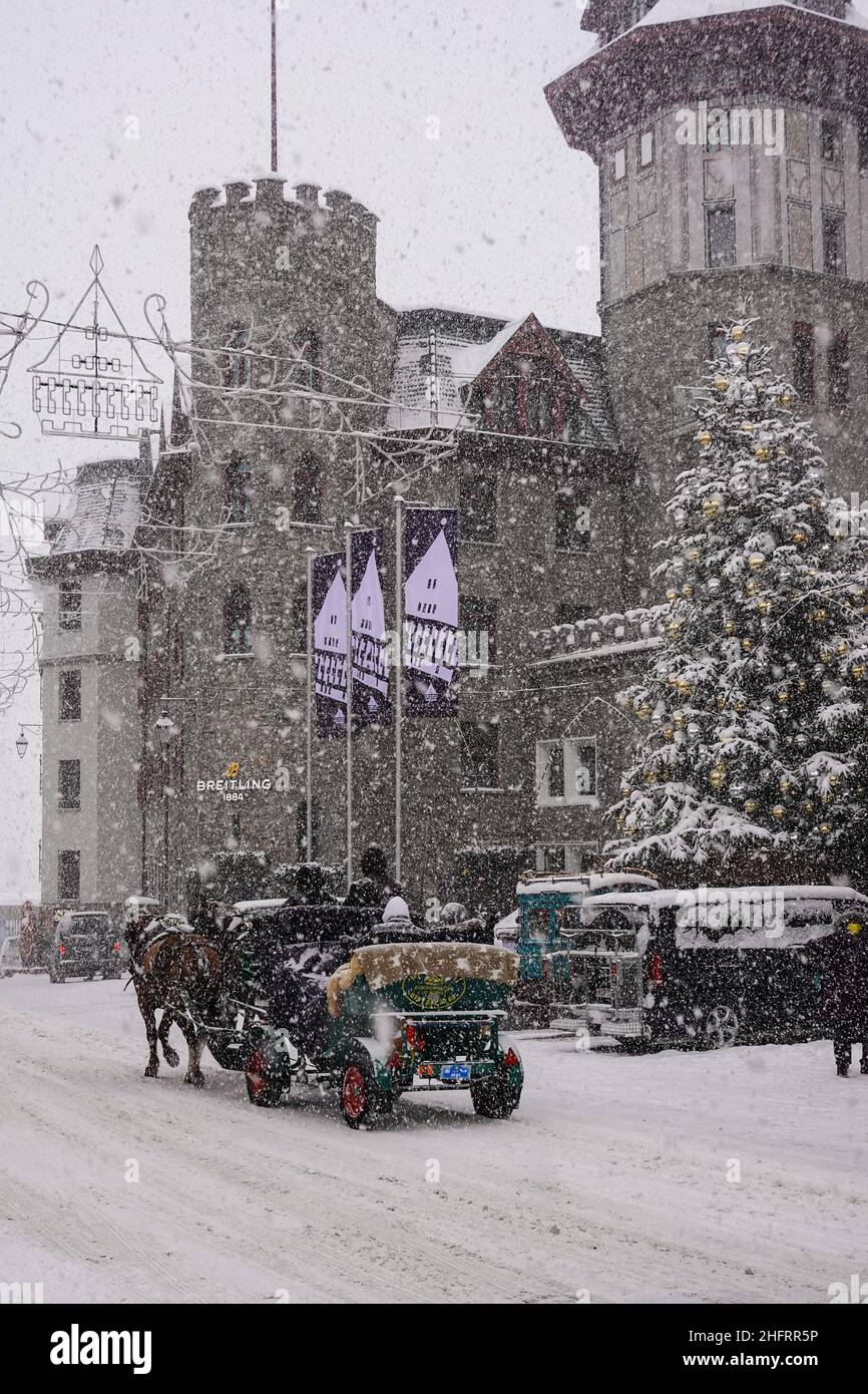 St Moritz, Suisse - décembre 08 2021 : une calèche attire des touristes devant le célèbre palais du Badrutt, dans le village de Saint Moritz Banque D'Images