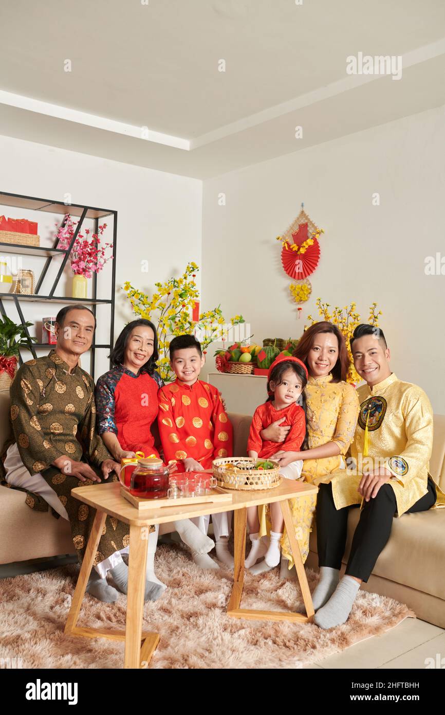 Grande famille rassemblée à la maison pour prendre du thé avec des bonbons et des fruits confits pour le nouvel an chinois Banque D'Images