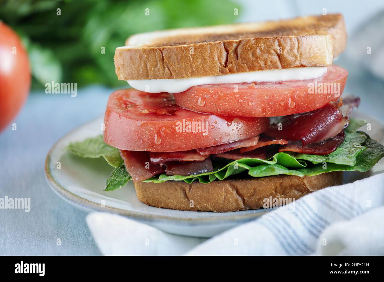 Sandwich maison au bacon, à la laitue et à la tomate sur une table rustique blanche.Mise au point sélective avec arrière-plan flou. Banque D'Images