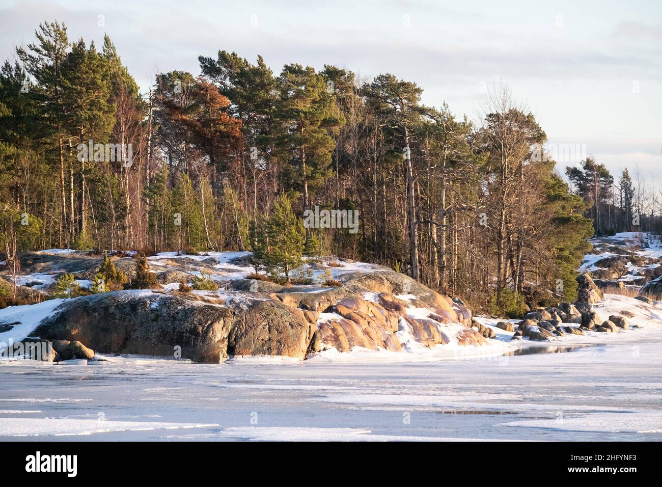 Helsinki / Finlande - 13 JANVIER 2022 : vue sur une petite île au-dessus d'une rivière gelée pendant une journée d'hiver ensoleillée. Banque D'Images