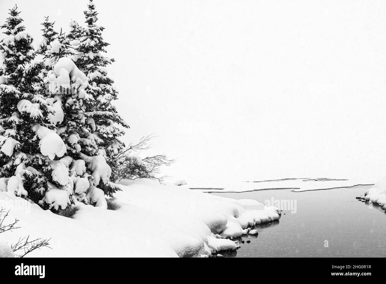 Parc national Yoho, Canada - décembre 23 2021 : le lac Emeraude gelé se cachant dans une forêt d'hiver surmontée par les montagnes rocheuses dans le parc national Yoho Banque D'Images