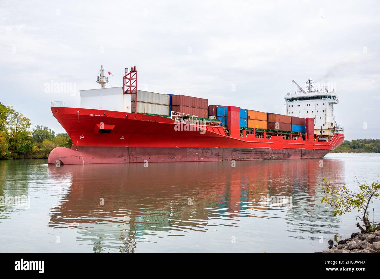 Bateau à conteneurs sur un canal navigable par une journée d'automne nuageux Banque D'Images
