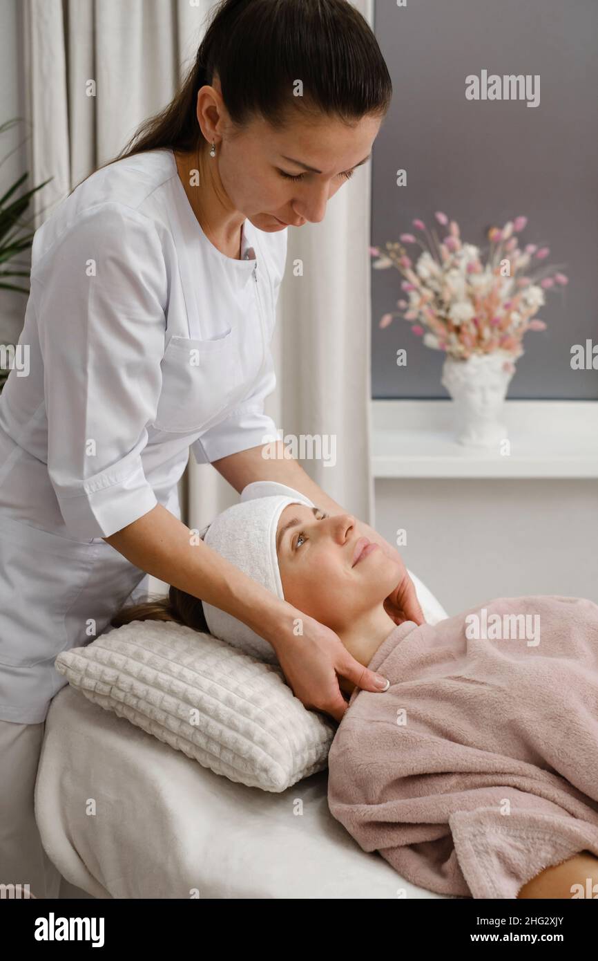 Femme heureuse au cosmetologiste, avant les soins et la procédure de traitement dans la clinique esthétique moderne.Femme se détendant au salon de beauté. Client souriant avec Banque D'Images