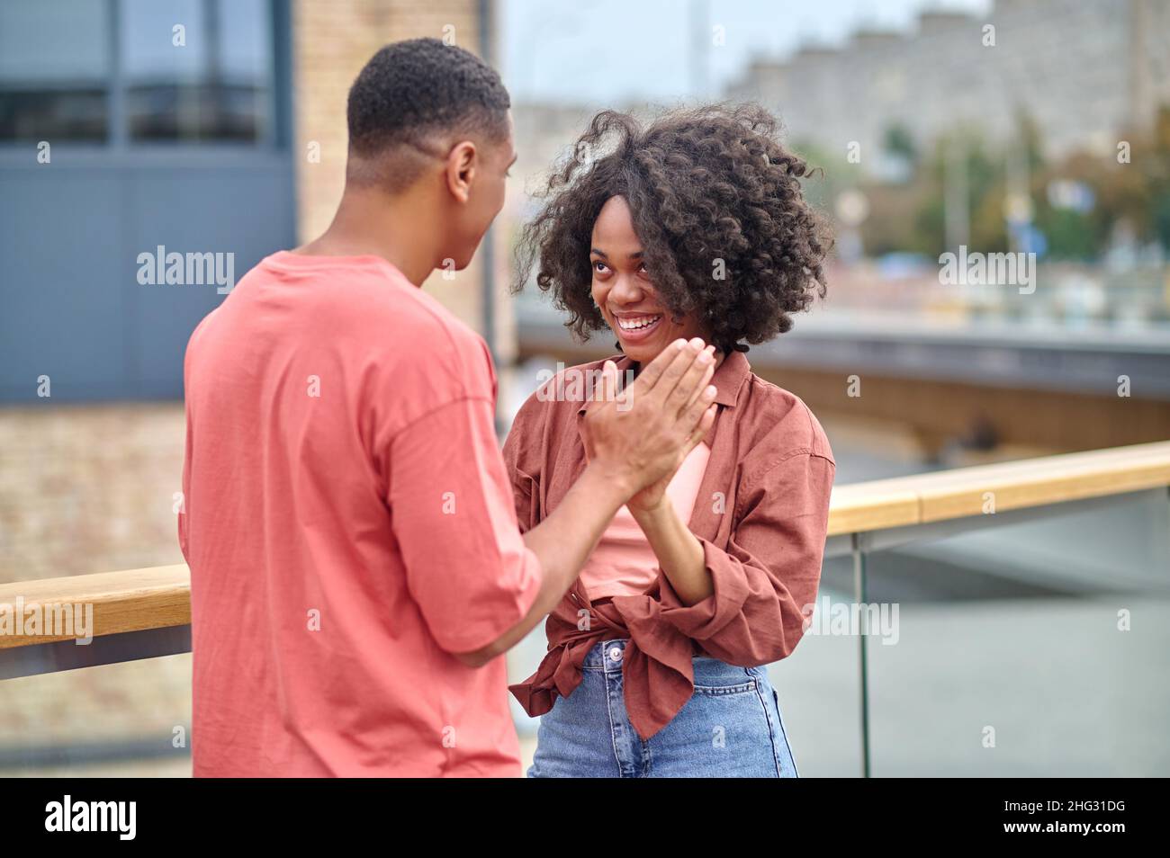 Femme et homme touchant les paumes debout sur le pont Banque D'Images