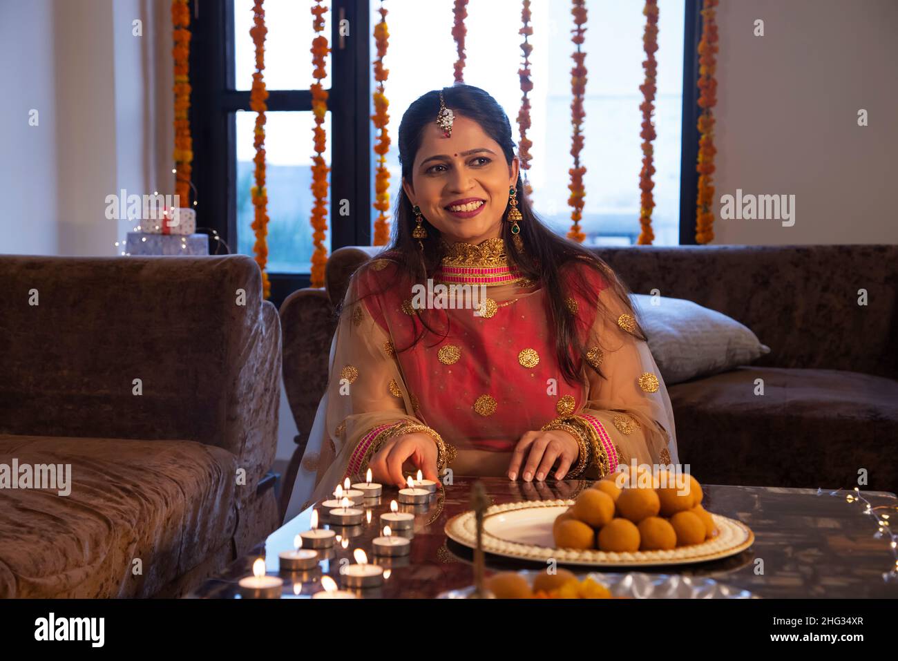 Femme indienne plaçant des diyas sur la table centrale à l'occasion de Diwali Banque D'Images