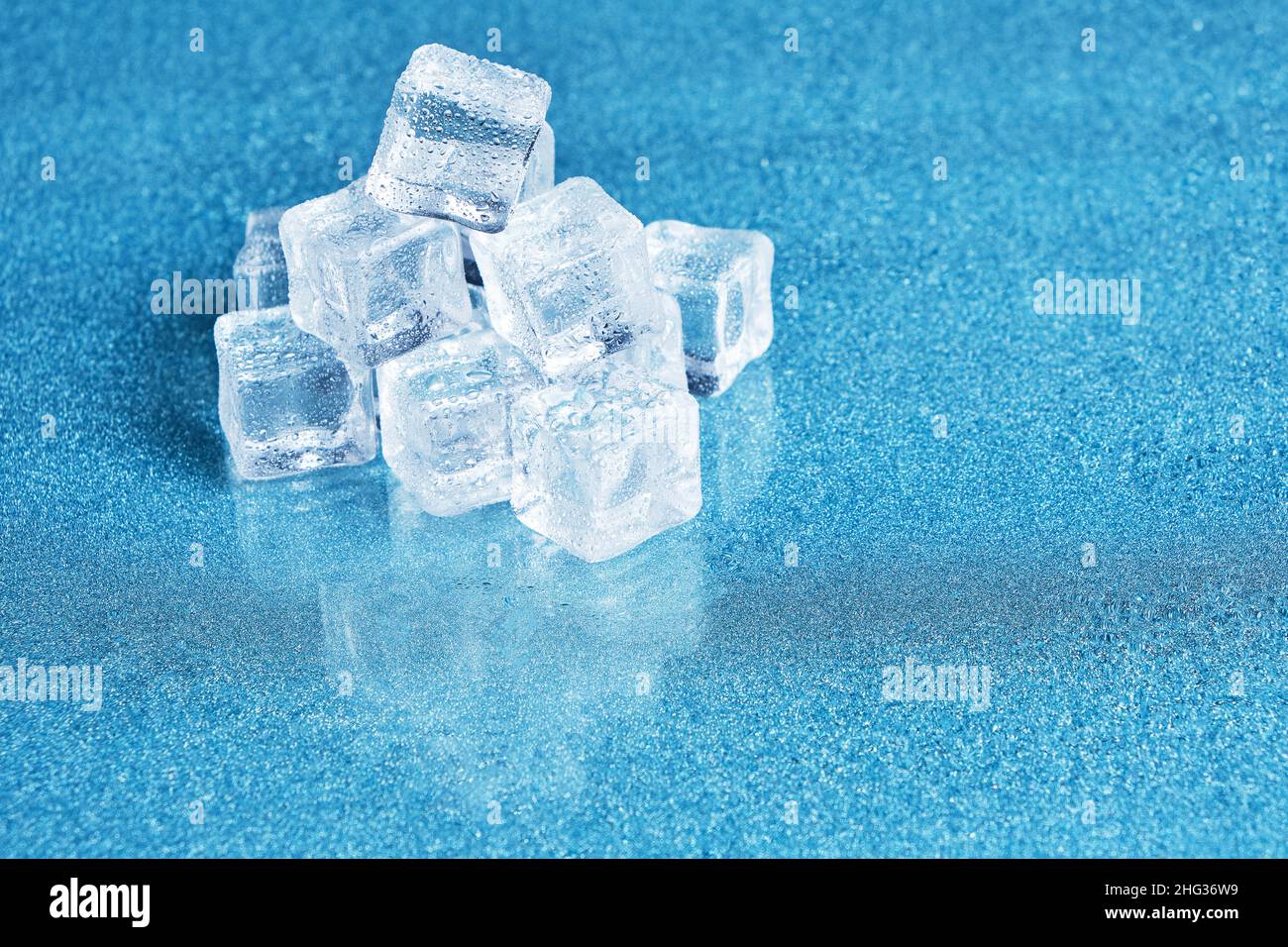 Les glaçons sont recouverts de gouttelettes d'eau sur fond bleu Banque D'Images