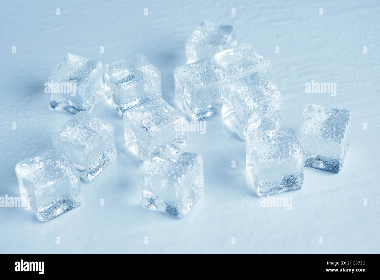 Les glaçons sont recouverts de gouttelettes d'eau sur un fond blanc Banque D'Images