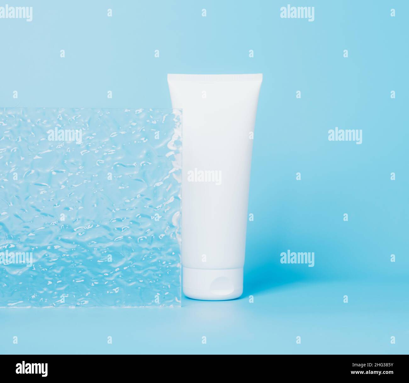 Produit cosmétique dans un tube, contenant blanc sur fond bleu.Shampooing, crème pour les mains, dentifrice emballage blanc Banque D'Images