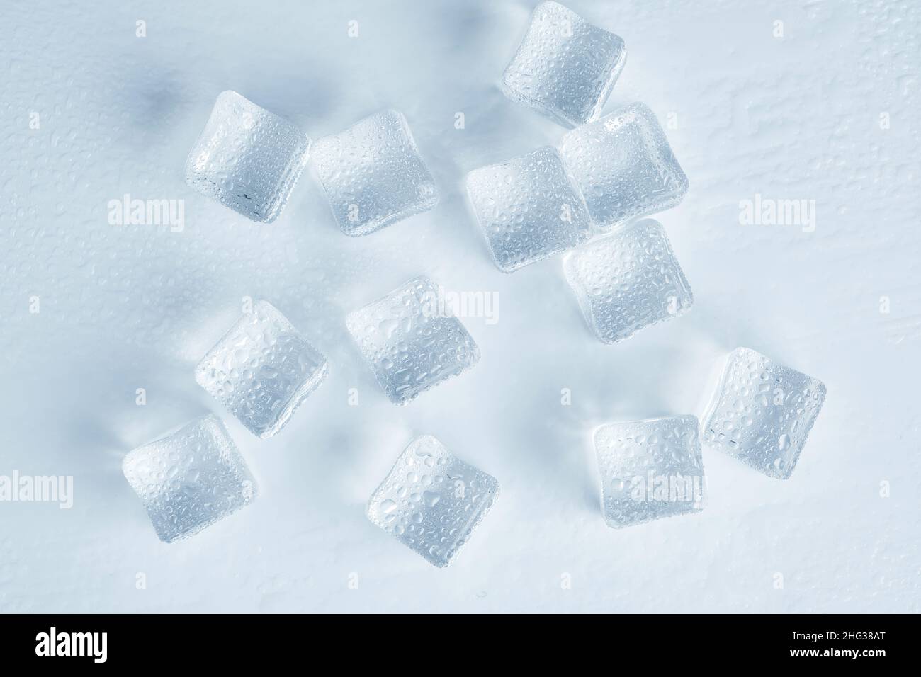 Les glaçons sont recouverts de gouttelettes d'eau sur un fond blanc Banque D'Images