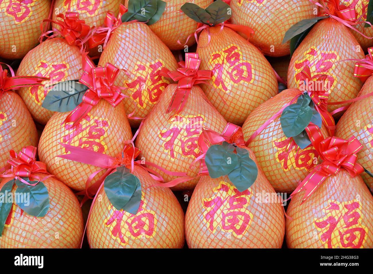 Gros plan d'un groupe de pomelos, avec le caractère chinois pour la bonne fortune ('fu'), à vendre dans un marché pour la saison de fête du nouvel an lunaire Banque D'Images