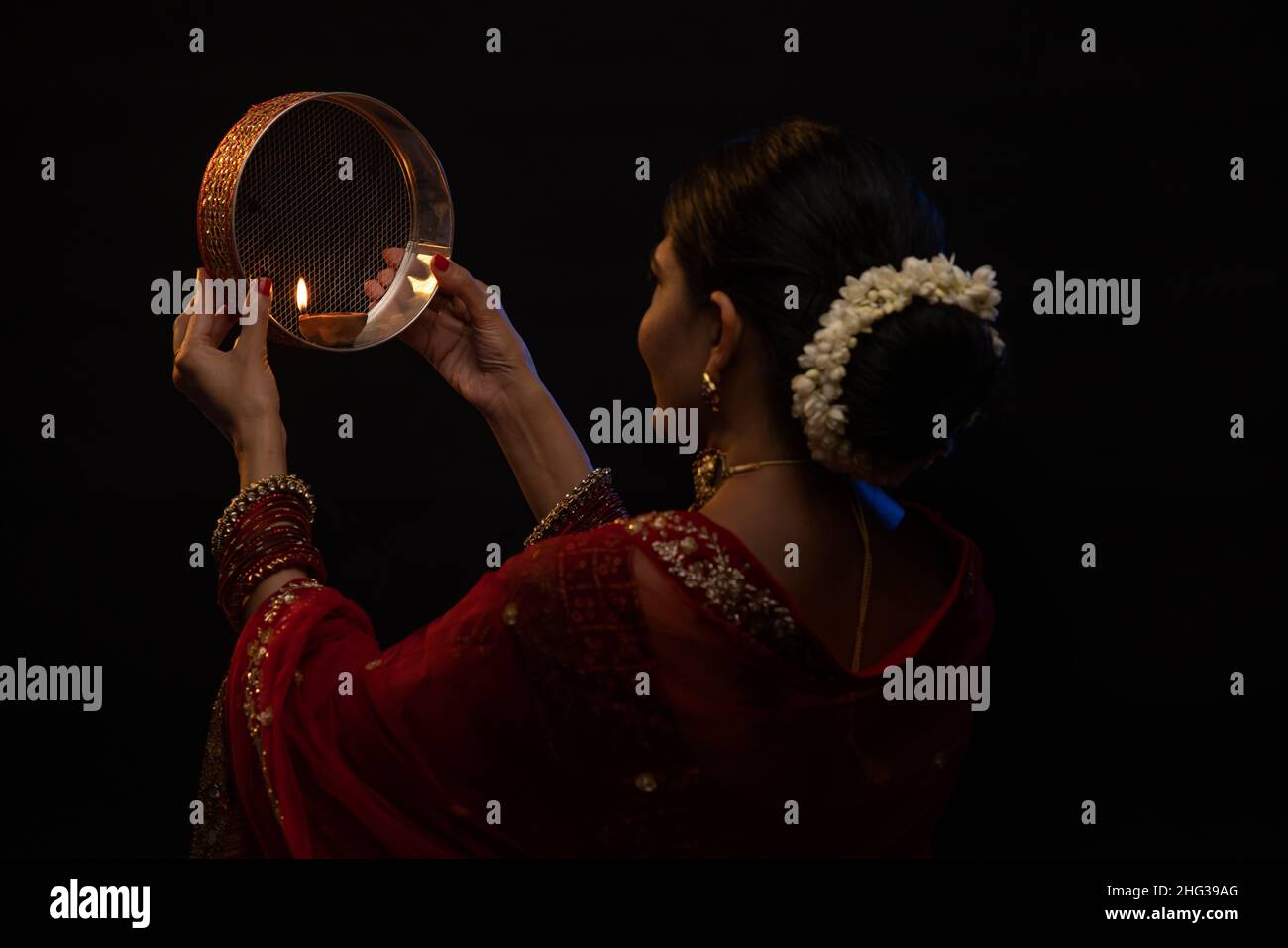 Femme regardant la lune à travers un tamis pendant Karva Chauth Banque D'Images
