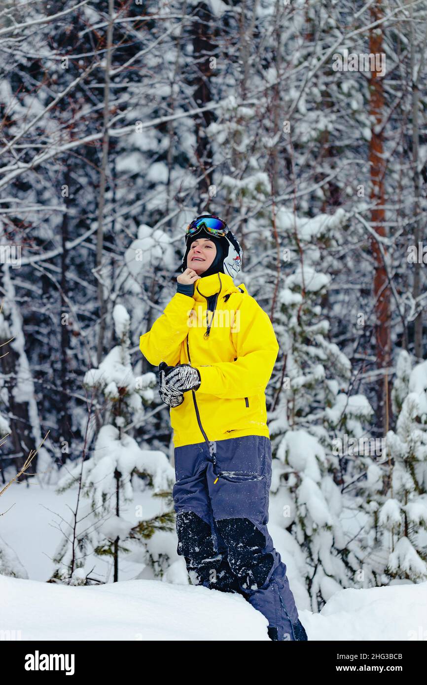 Portrait d'une jeune femme snowboardeuse en vêtements d'hiver brillants.Une femme d'origine caucasienne passe du temps dans un parc de snowboard enneigé.Vacances d'hiver Banque D'Images