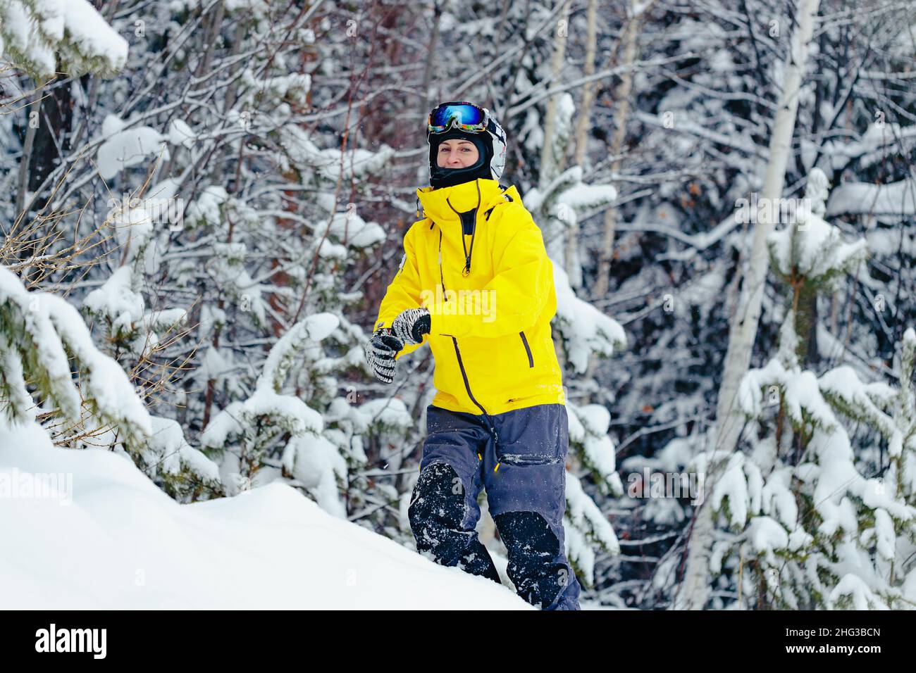 Portrait d'une jeune femme snowboardeuse en vêtements d'hiver brillants.Une femme d'origine caucasienne passe du temps dans un parc de snowboard enneigé.Vacances d'hiver Banque D'Images