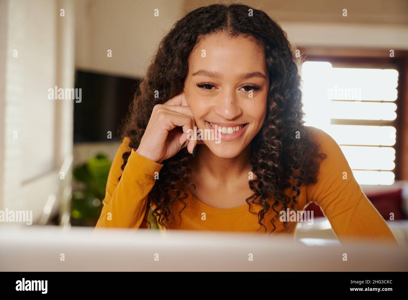 Femme afro-américaine souriant lors d'un appel vidéo avec des clients Banque D'Images