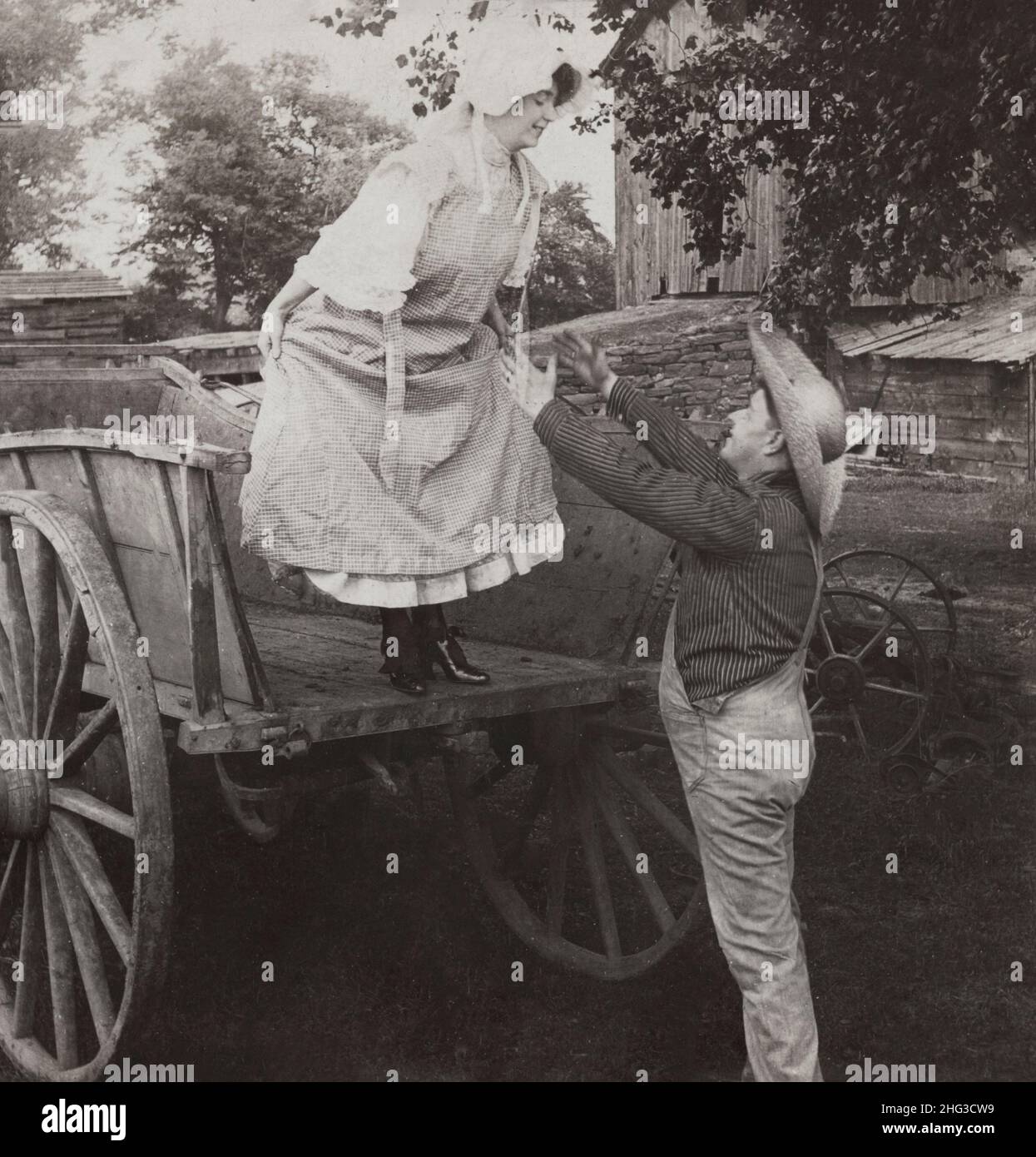 Photo vintage des amoureux.« Catch Me Tom ! ».ÉTATS-UNIS.1906 femme sur le point de sauter du wagon dans les bras d'un fermier. Banque D'Images