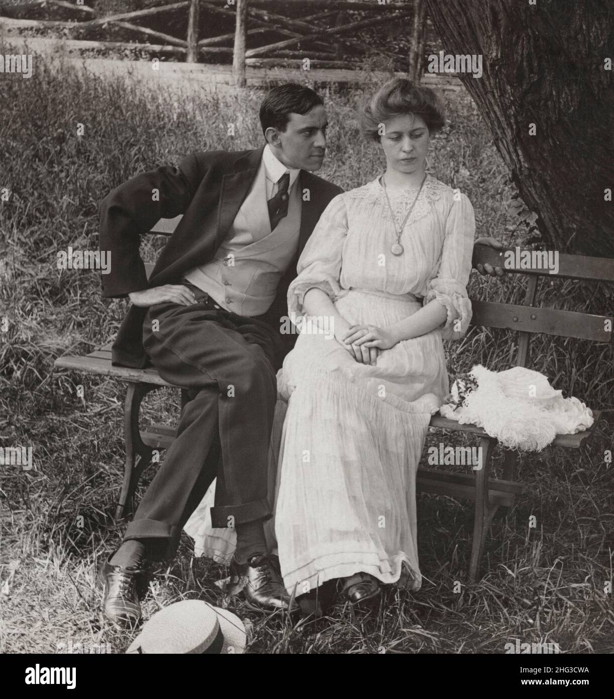 Photo d'amour vintage.Quand l'amour est jeune.1906 couple assis sur un banc. Banque D'Images
