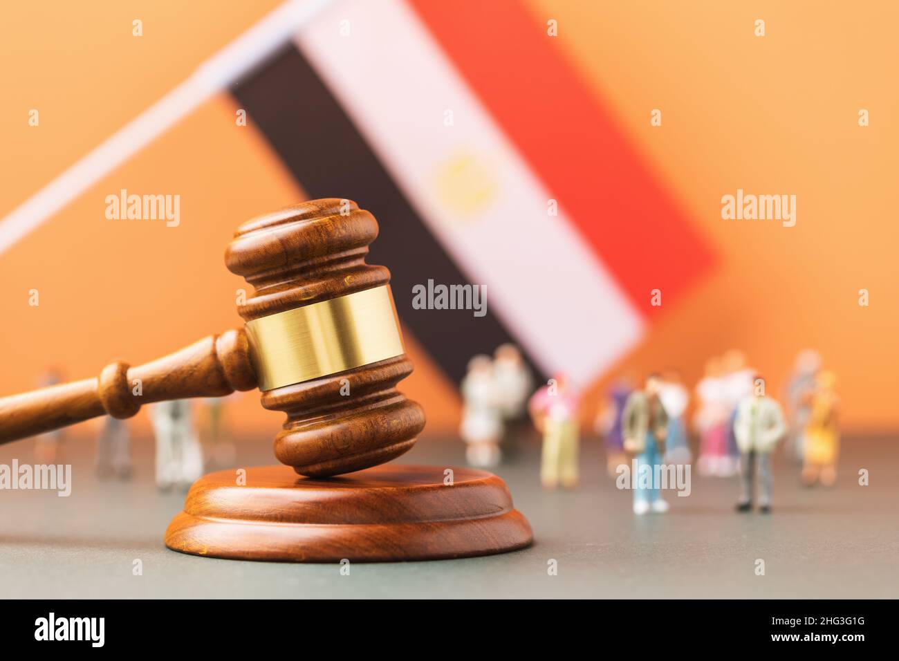 Gavel juge en bois, drapeau et jouets en plastique sur fond coloré, concept de procès dans la société égyptienne Banque D'Images