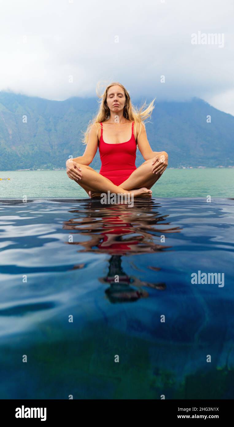 Une jeune fille pratique le yoga au bain à remous du volcan Batur.Voyage à Kintamani, Bali.Une femme médite dans la piscine à débordement avec vue sur le lac.Un mode de vie sain Banque D'Images