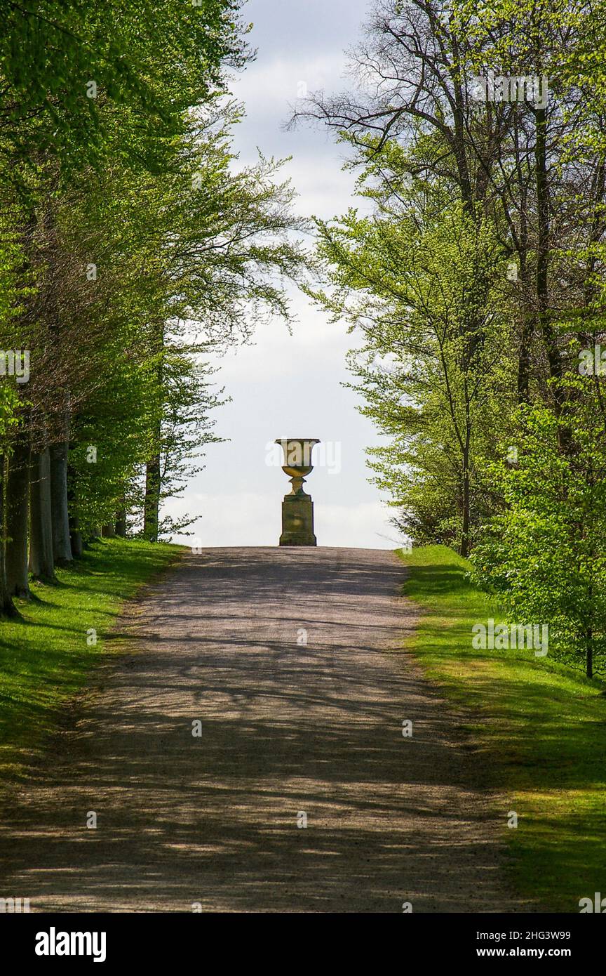 Ornement en pierre et plinthe au bout d'un chemin bordé d'arbres dans le domaine de Chatsworth House, Derbyshire, Royaume-Uni Banque D'Images