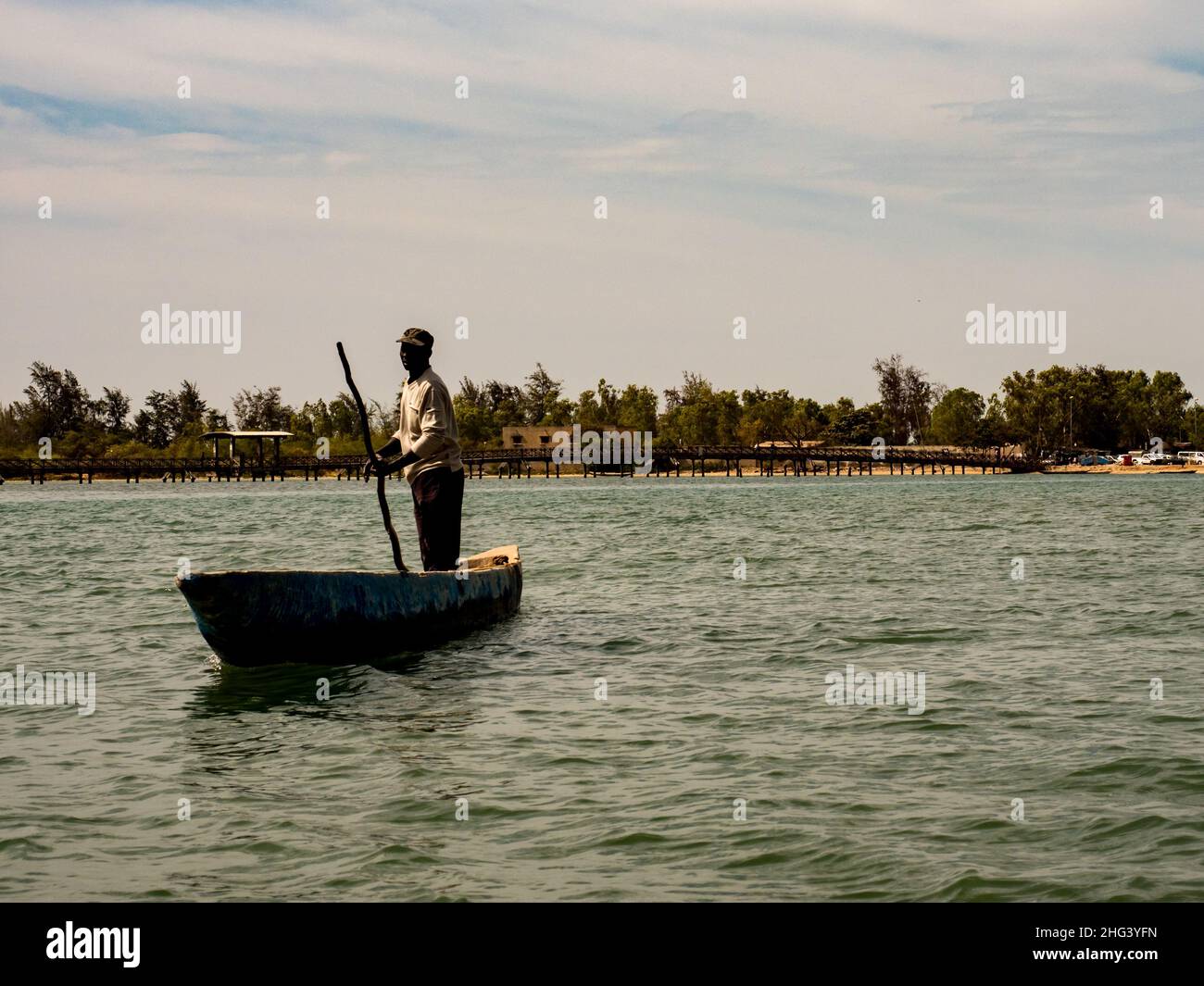 Joal-Fadiouth, Sénégal, Afrique - Jan 2019 : un homme africain qu'il se pousse avec un poteau sur un petit canot en bois dans la mer entre Joel et Fadiou Banque D'Images