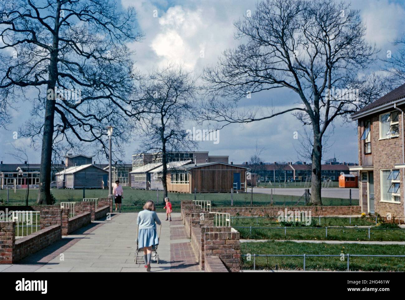 Une vue à l'ouest le long de Sherwood Walk dans la région de Tilgate de Crawley 'New Town', West Sussex, Angleterre, Royaume-Uni en 1966.L'école primaire Oaks est en arrière-plan.Le quartier, au sud du centre-ville, était l'une des 14 banlieues développées pour créer la nouvelle ville d'après-guerre.Après la Seconde Guerre mondiale, afin de relocaliser ceux qui vivent dans des logements pauvres ou bombardés à Londres, un grand nombre de personnes et d’emplois ont été transférés dans de nouvelles villes autour de la se Angleterre et Crawley en était une.En 1960, la Corporation de développement avait construit 10 254 maisons et des constructeurs privés environ 1 500 autres – une photographie vintage de 1960s. Banque D'Images