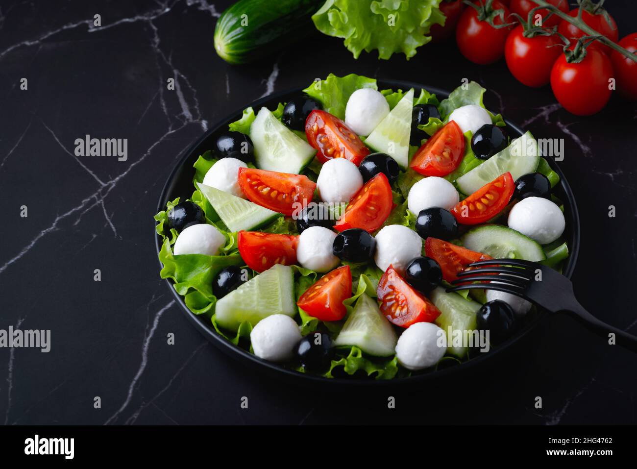 Salade fraîche avec concombres, tomates, olives noires et feta ou mozzarella Banque D'Images