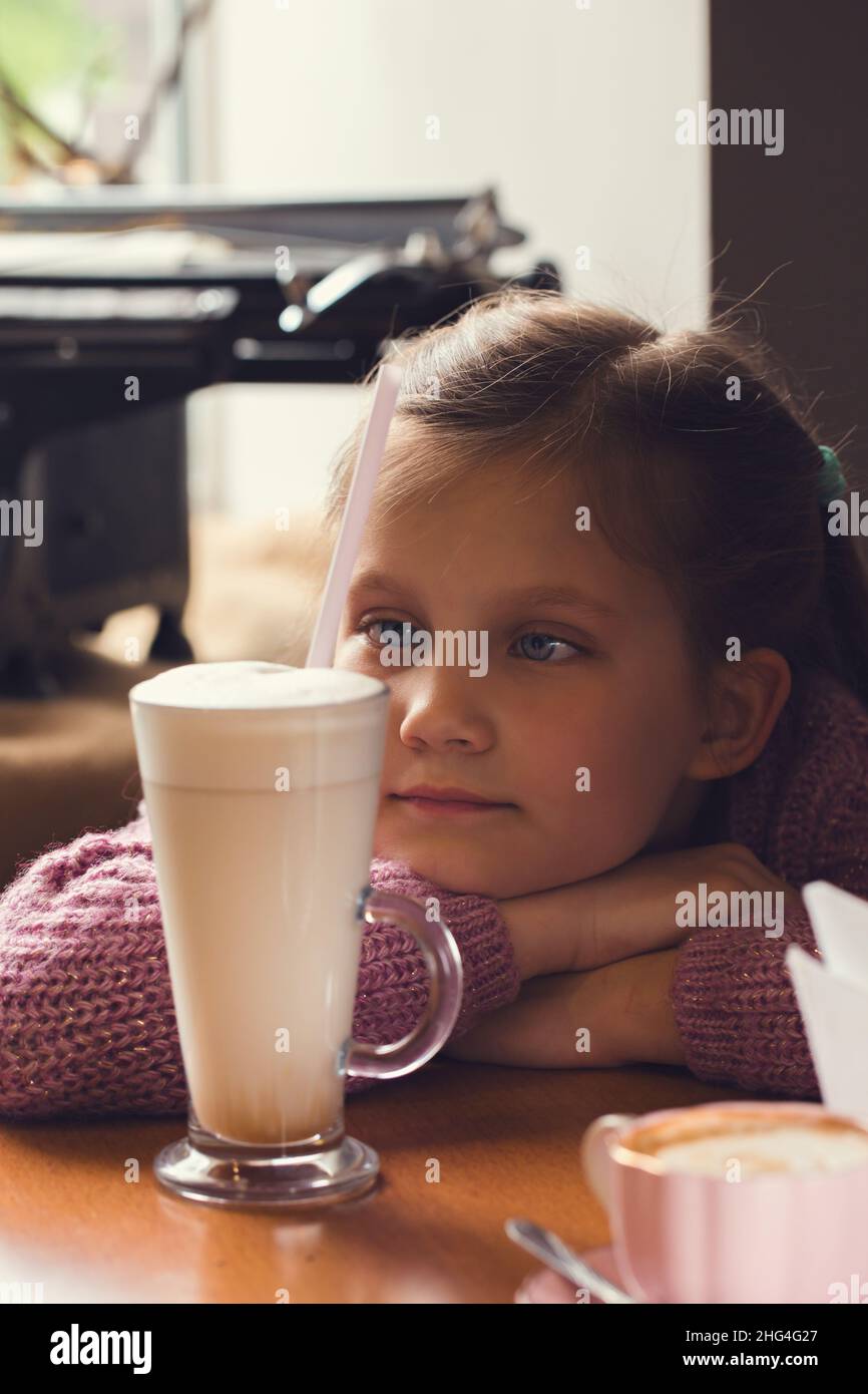 Triste fille dans un café avec un verre de cacao Banque D'Images