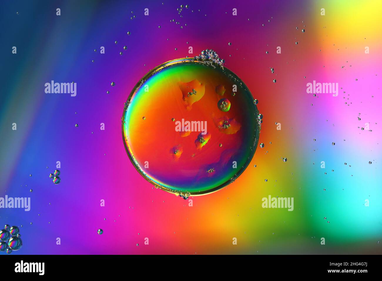 gros plan d'une goutte d'huile sur une surface d'eau éclairée, arrière-plan abstrait Banque D'Images