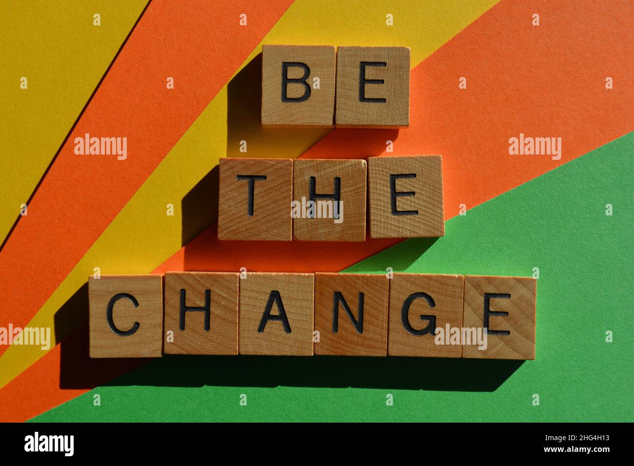 Be the change, mots en lettres de l'alphabet en bois isolées sur fond multicolore Banque D'Images