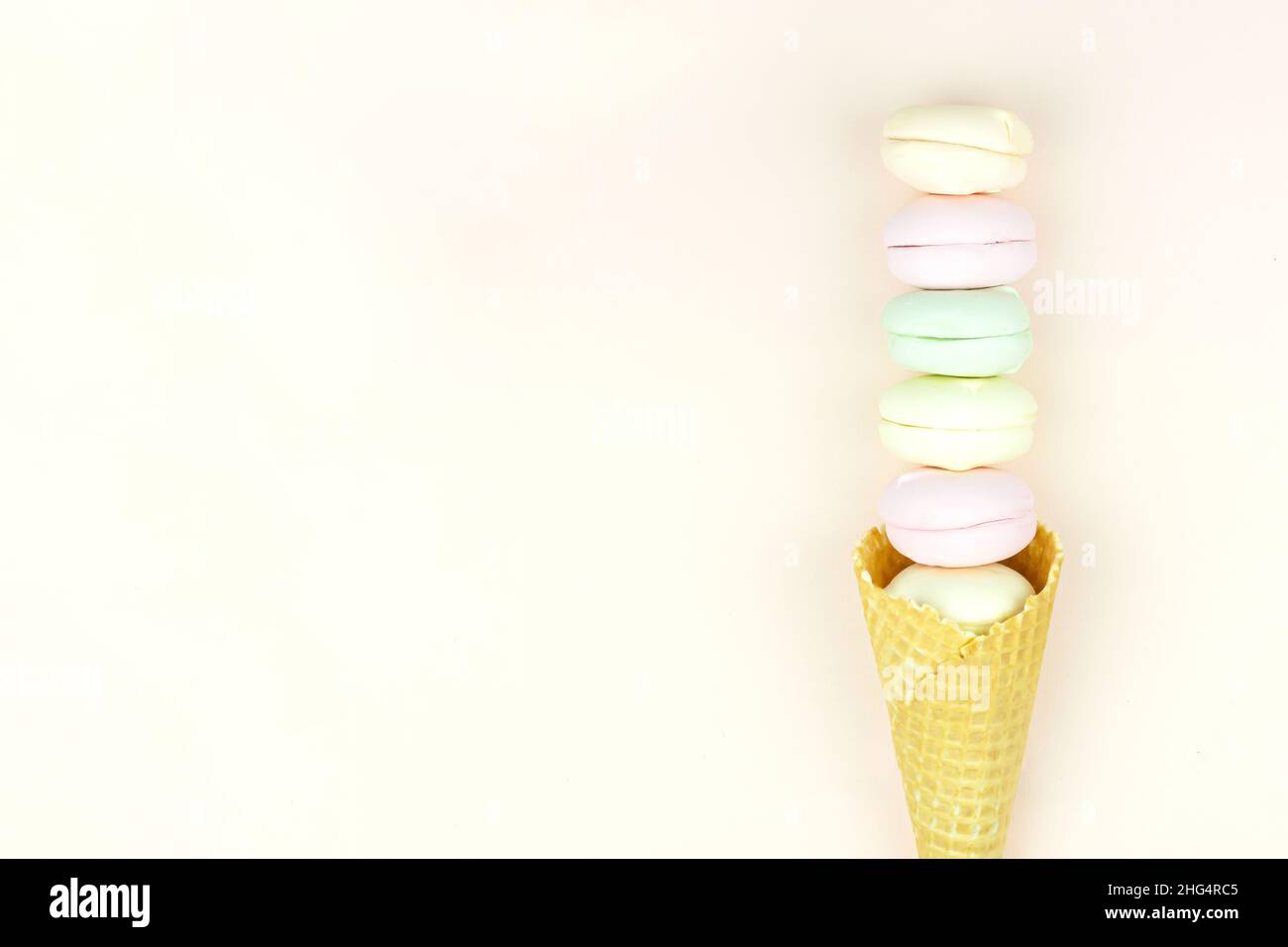 Le cornet à motif gaufré avec guimauve colorée ressemble à des macarons sur fond rose pastel.vue du dessus.Espace libre pour le texte Banque D'Images