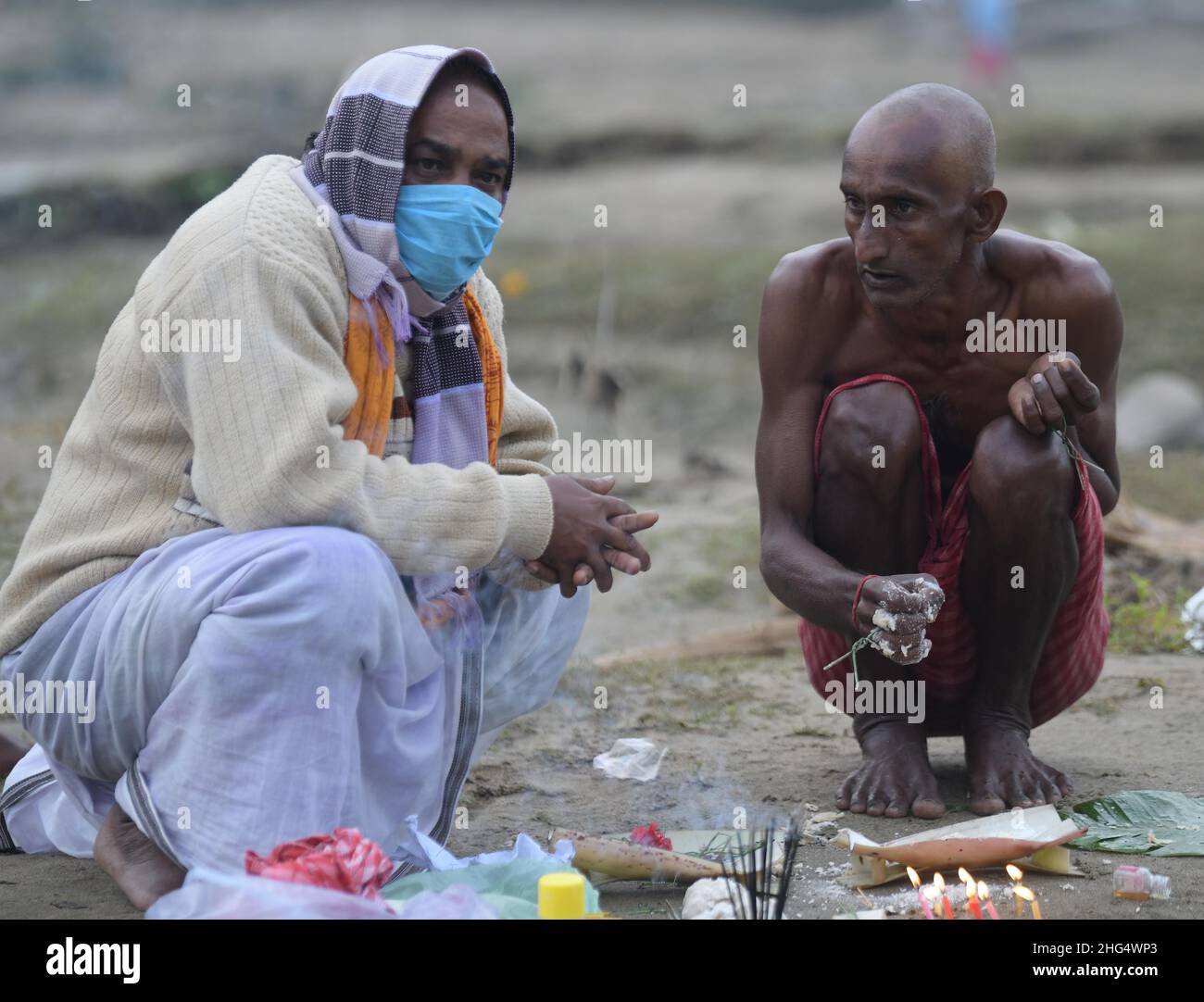 Bengali et hindou tribal des dévotés faisant différents rituels et priant pour les âmes de leurs ancêtres par une banque de rivière.Le festival Makar Sankranti qui coïncide avec la récolte d'hiver est considéré comme l'un des jours les plus favorables du calendrier hindou.Agartala, Tripura, Inde. Banque D'Images