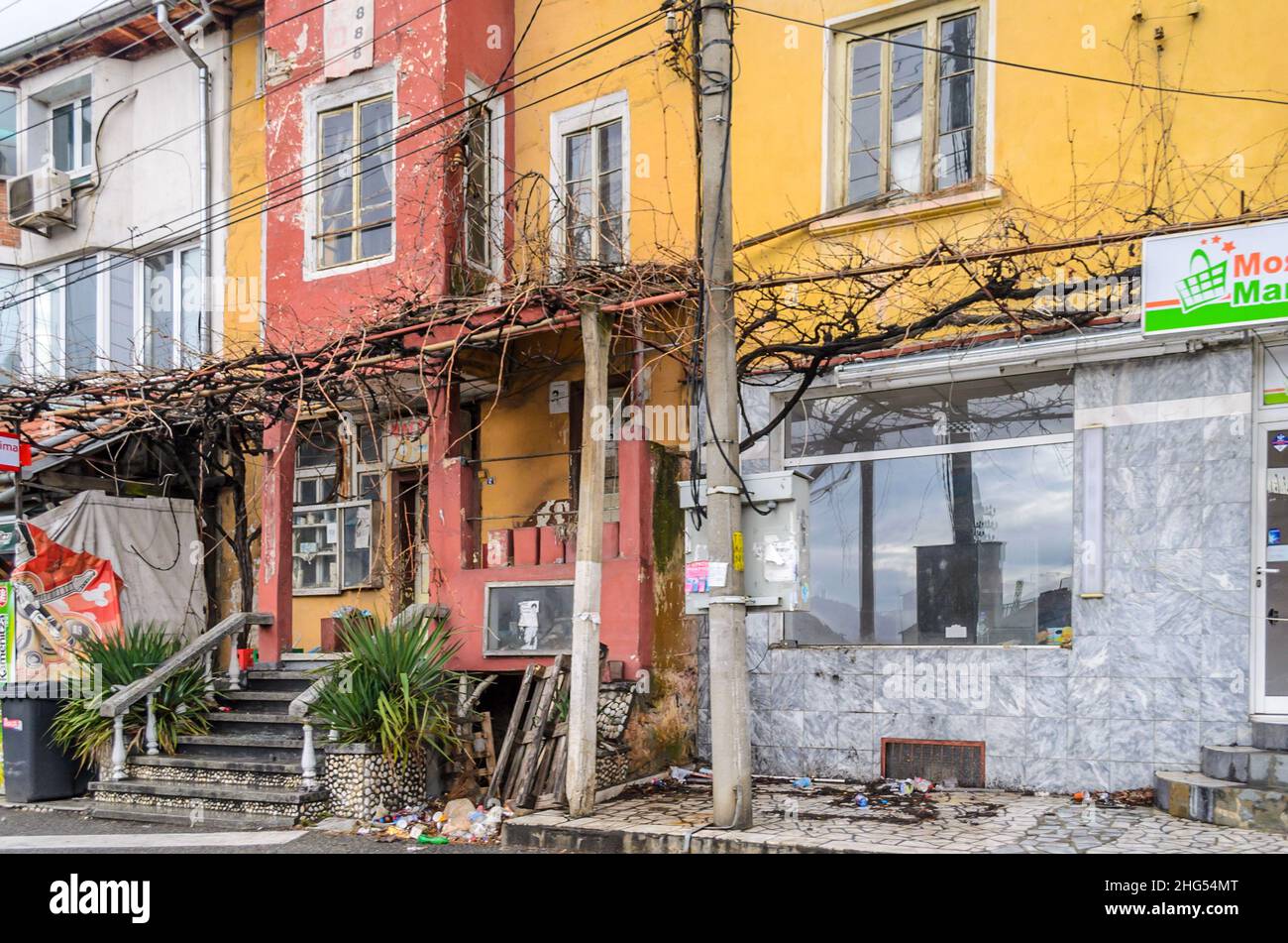 Magasins et maisons abandonnés dans un quartier pauvre en Bulgarie du Sud, dans les Balkans, en Europe.Bâtiments multicolores en mauvais état dans une rangée. Banque D'Images