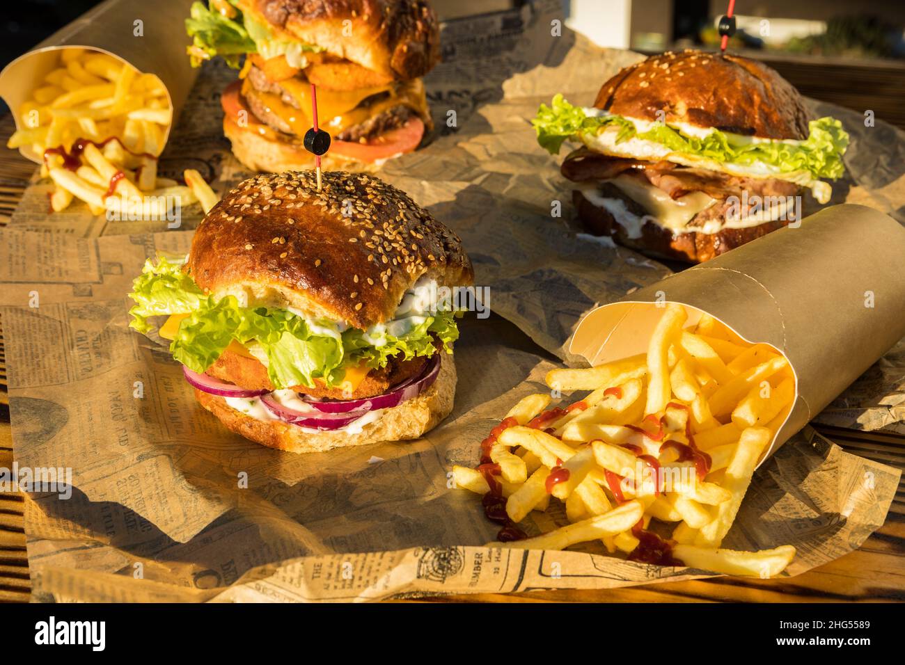 Trois hamburgers aux frites trempés dans une sauce ketchup prête à manger Banque D'Images