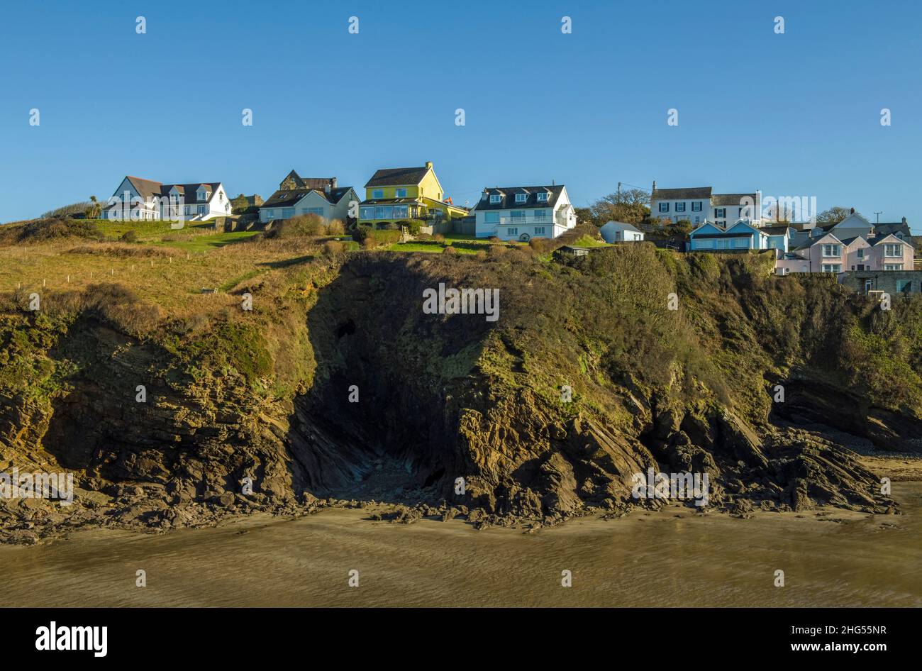 Vue sur la plage de Little Haven jusqu'aux maisons en haut de la falaise sur la côte de Pembrokeshire dans l'ouest du pays de Galles, le jour de janvier ensoleillé Banque D'Images