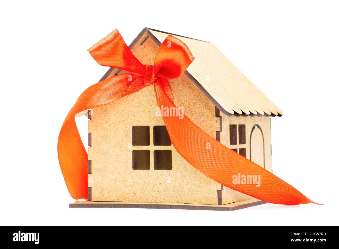 Vue à angle bas d'un modèle de maison avec un ruban rouge et un noeud isolé sur fond blanc.Concept d'achat à la maison Banque D'Images