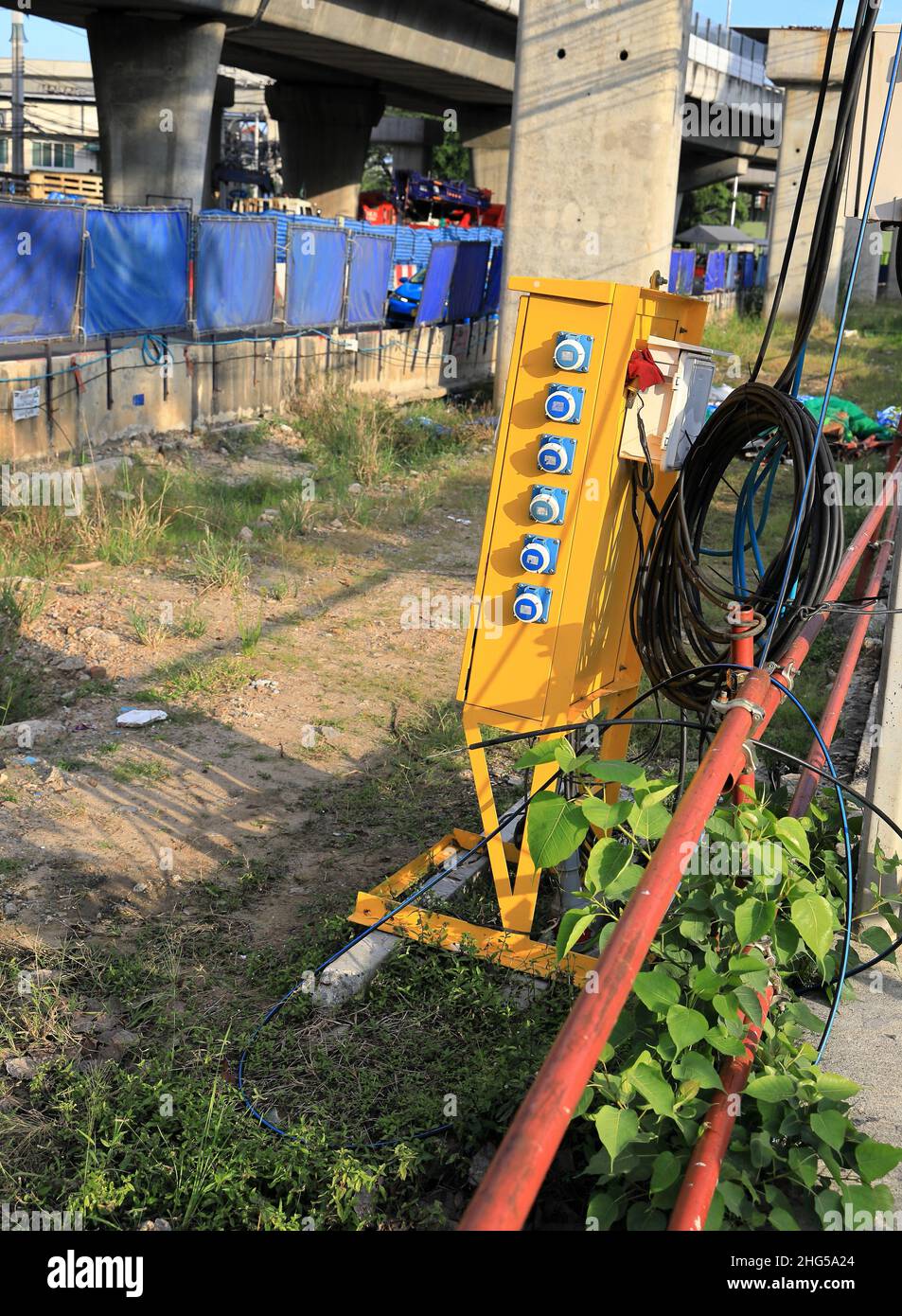 Commandes d'armoire en métal jaune pour la distribution de l'alimentation électrique a sur le chantier de construction. Banque D'Images