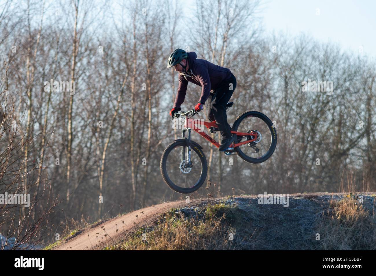 Homme à vélo BMX sautant sur des collines et des obstacles sur la piste de saut à vélo d'Edenbrook Country Park, Fleet, Hampshire, Royaume-Uni Banque D'Images
