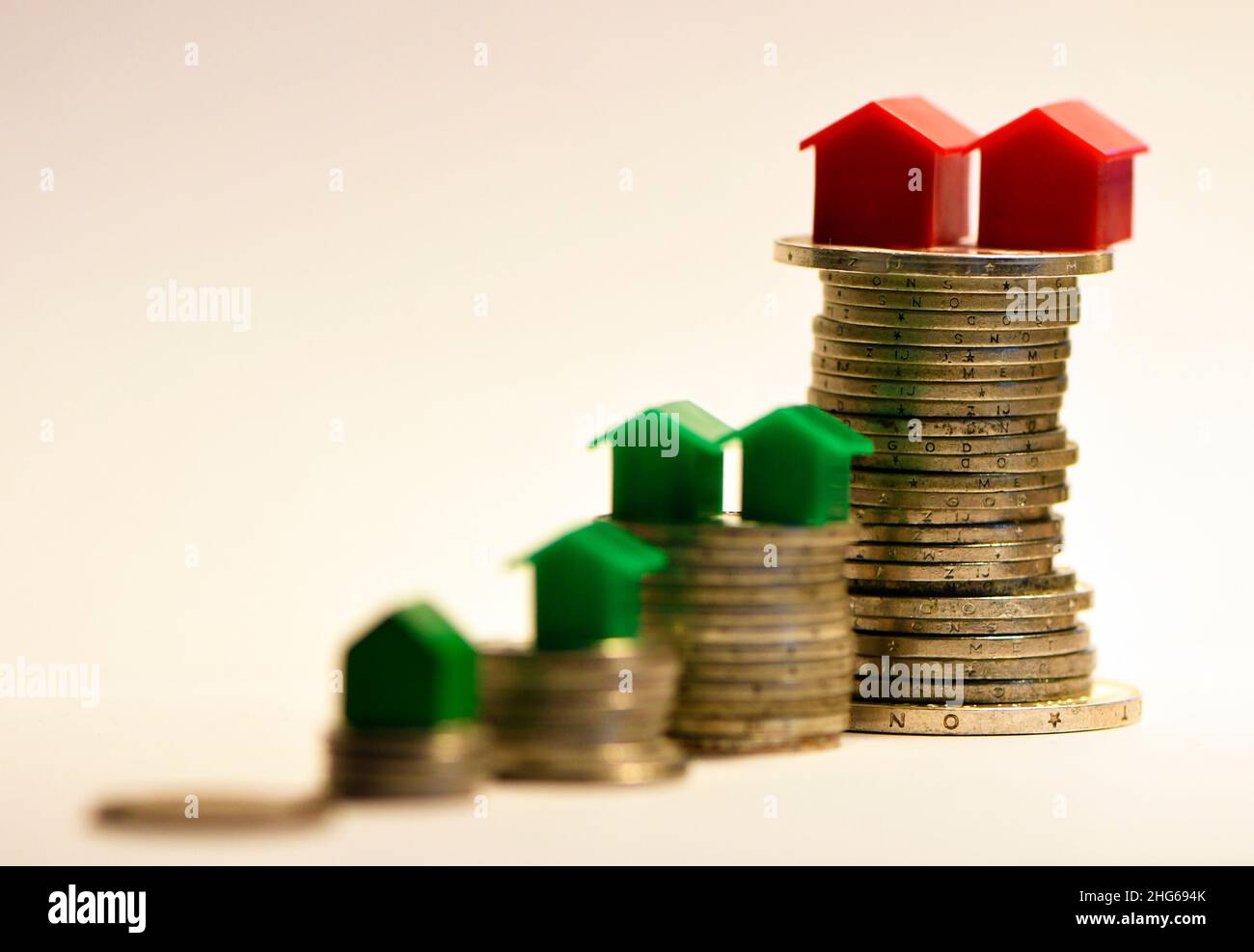 L'inégalité financière s'exprime sous la forme de différences dans les différences de hauteur des pièces de monnaie et dans la propriété de la maison Banque D'Images