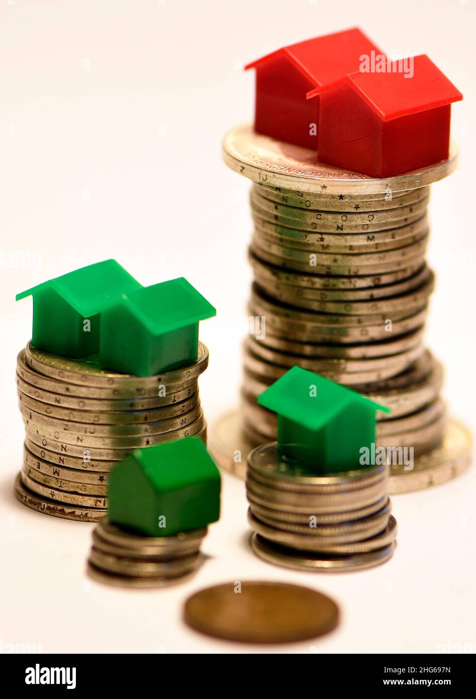 L'inégalité financière s'exprime sous la forme de différences dans les différences de hauteur des pièces de monnaie et dans la propriété de la maison Banque D'Images